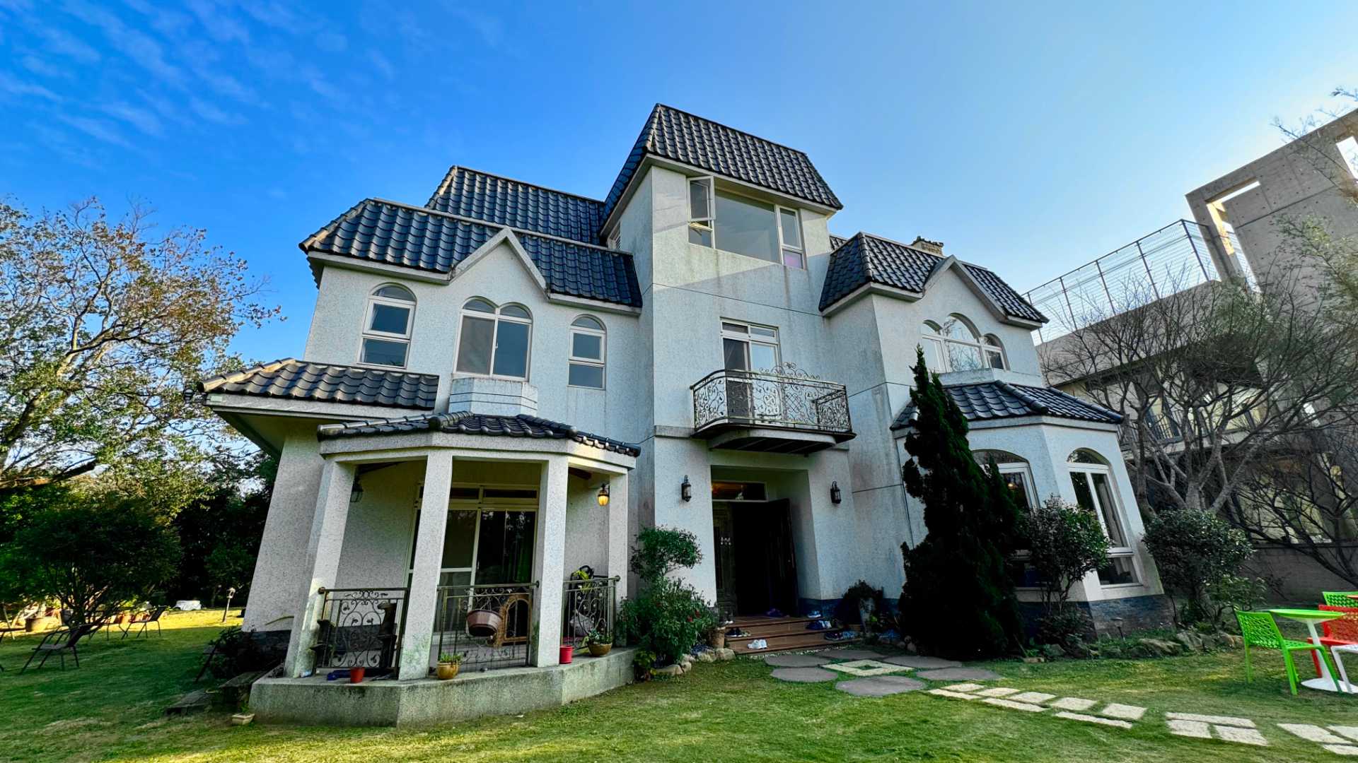 A three-story house in a leafy Taoyuan garden.