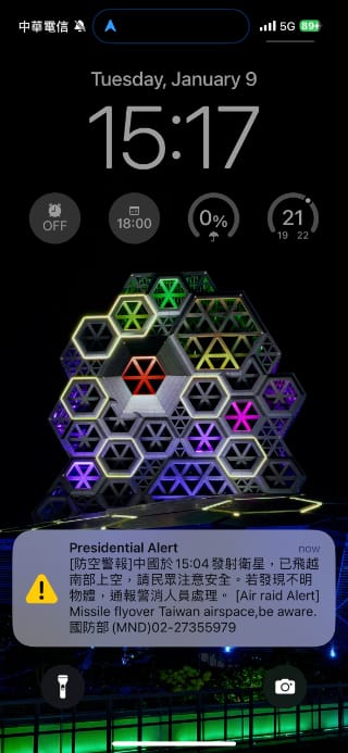 Screenshot of a Presidential Alert on an iPhone lock screen. The English part of the alert says: ‘[Air raid Alert] MIssile flyover Taiwan airspace,be aware.’