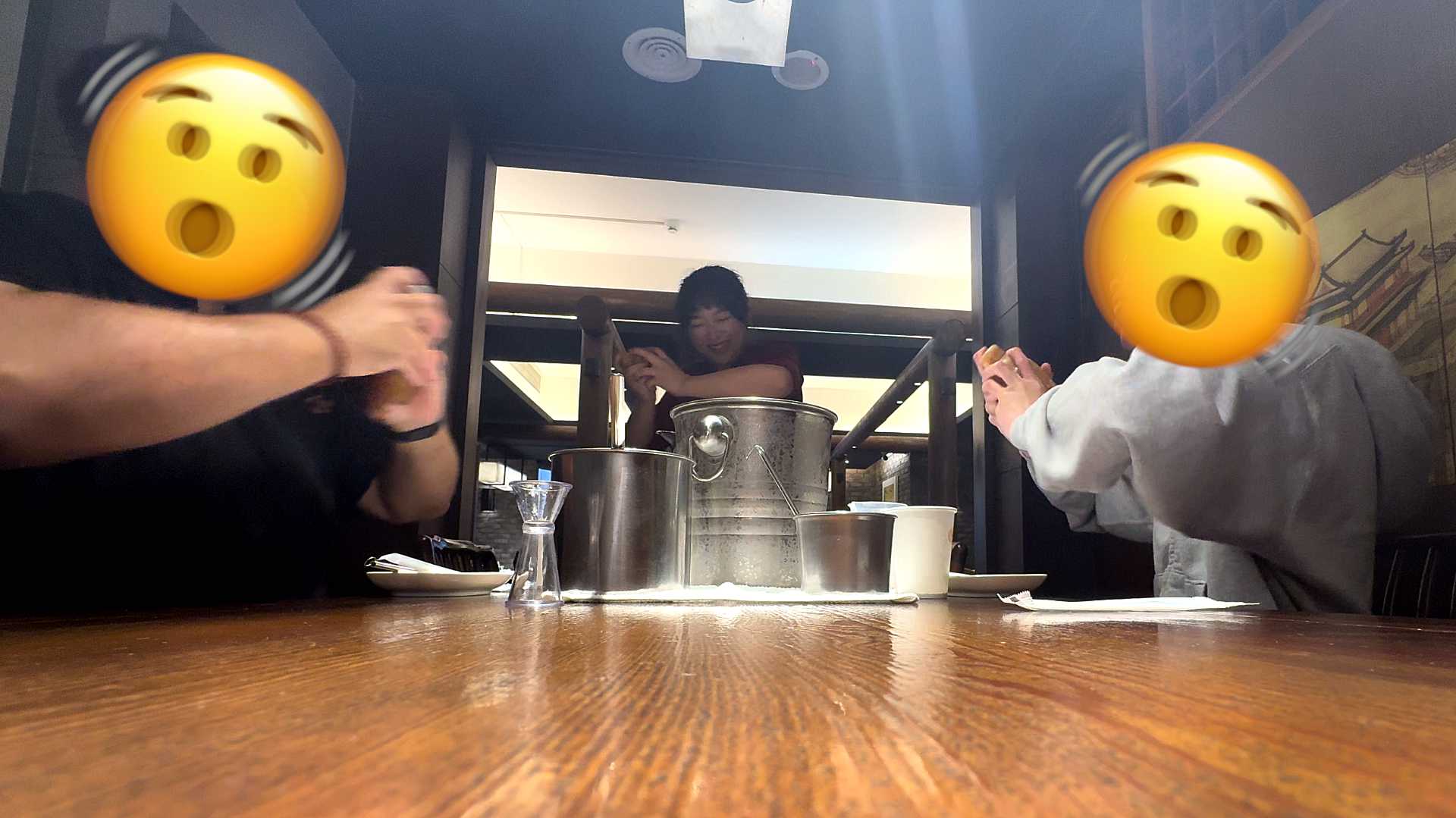 Three people shaking cocktail shakers. The faces of the men on the left and right side of the table are obscured by shaking-style emoji faces. The female teacher is unobscured at the far end of the table.