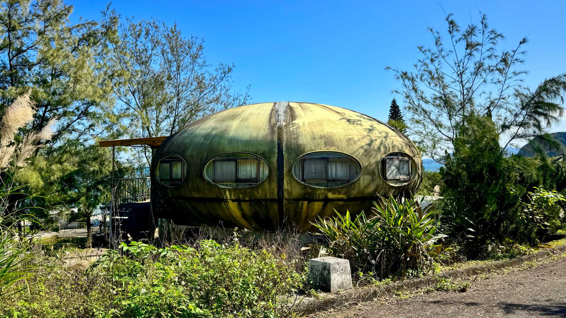 A flying saucer-style house, the Futuro. It appears to be covered in mold.