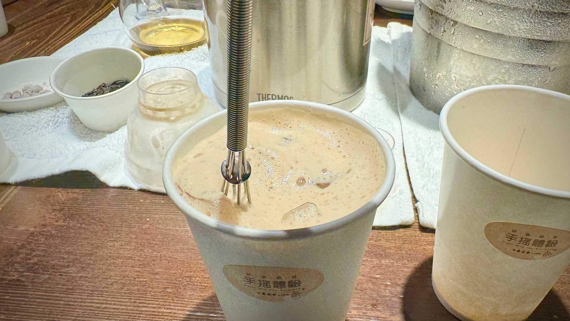 Whisking a cup of iced bubble tea.
