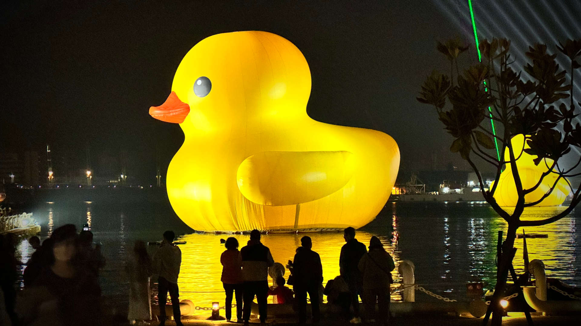 Night view of two large yellow ducks floating on Kaohsiung Harbor.