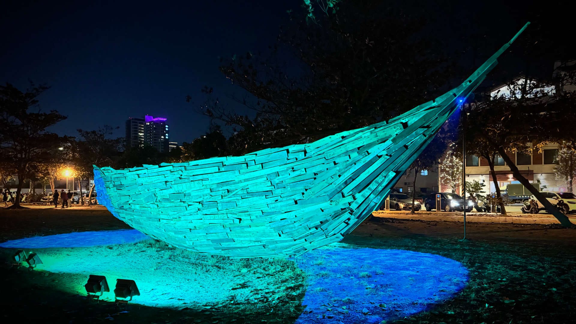 An illuminated sculpture resembling a large wooden boat.