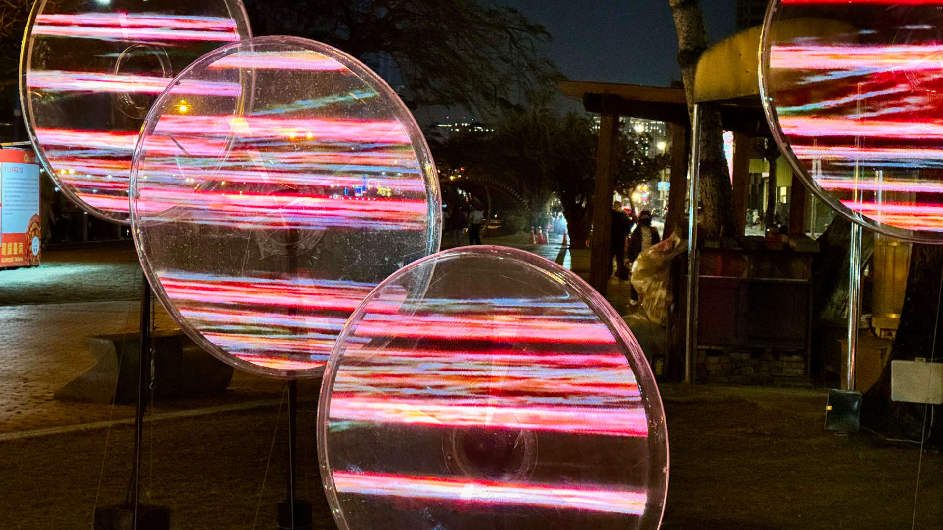 LED lights on four spinning fans are computer-controlled to display abstract horizontal bands of color.