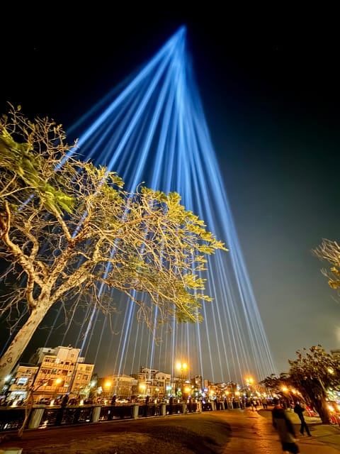 Dozens of spotlights, either side of Tainan Canal, projecting beams of light to a point of convergence very high in the sky.