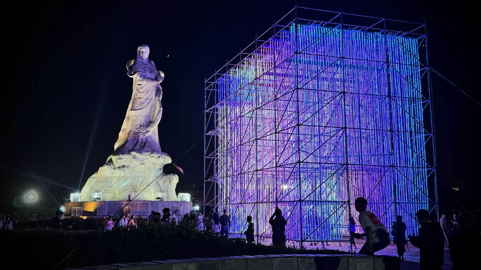 The Journey of Prosperity art installation – a cube-like shape comprising thousands of strands of hanging lights, with a large classical statue in the background.