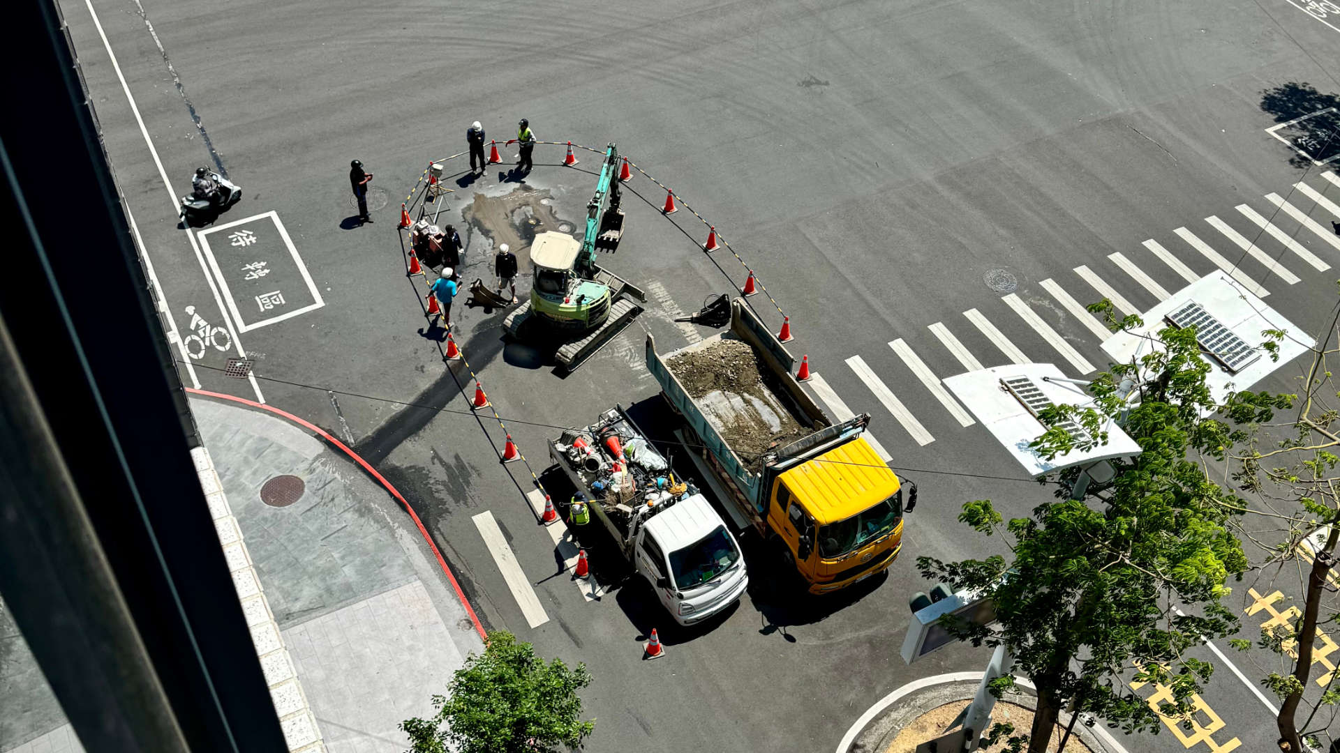Construction crew repairing a broken water pipe at a six-lane intersection in Kaohsiung, Taiwan.