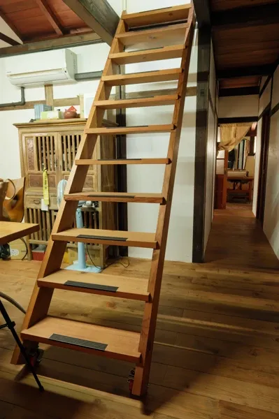 A wooden ladder leading to the attic.