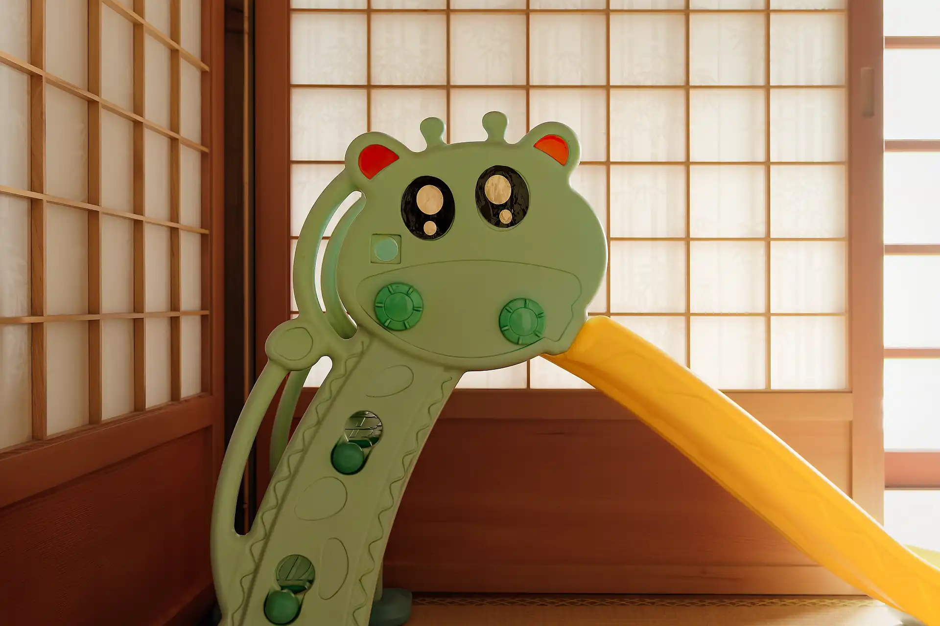 A children’s plastic slide on tatami mats, in front of shoji screens.
