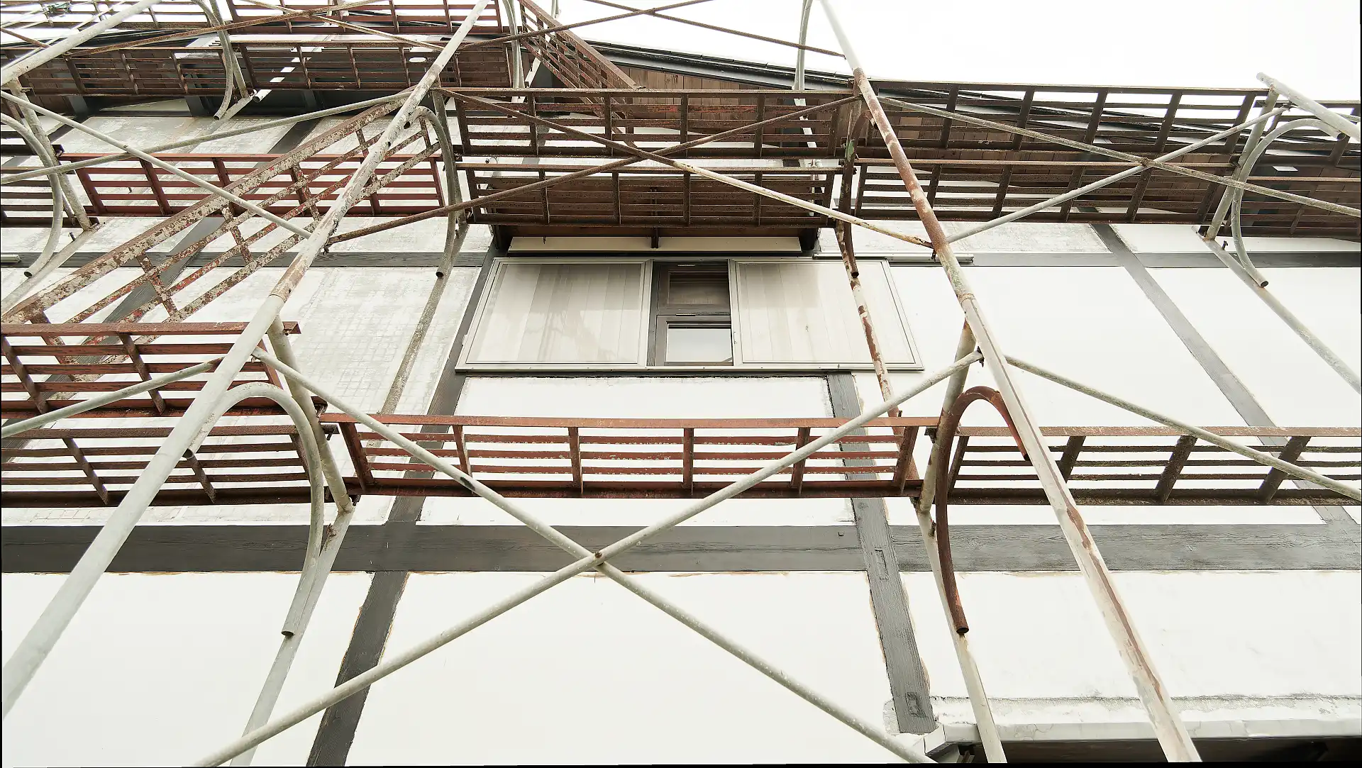 Three-story high metal scaffolding along one wall of ‘A Book Wooden House’.