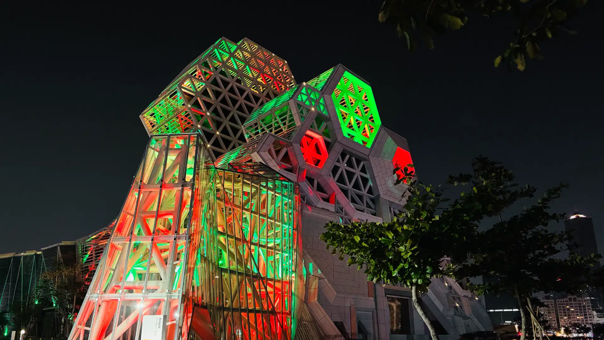 Kaohsiung Music Center illuminated in red and green.