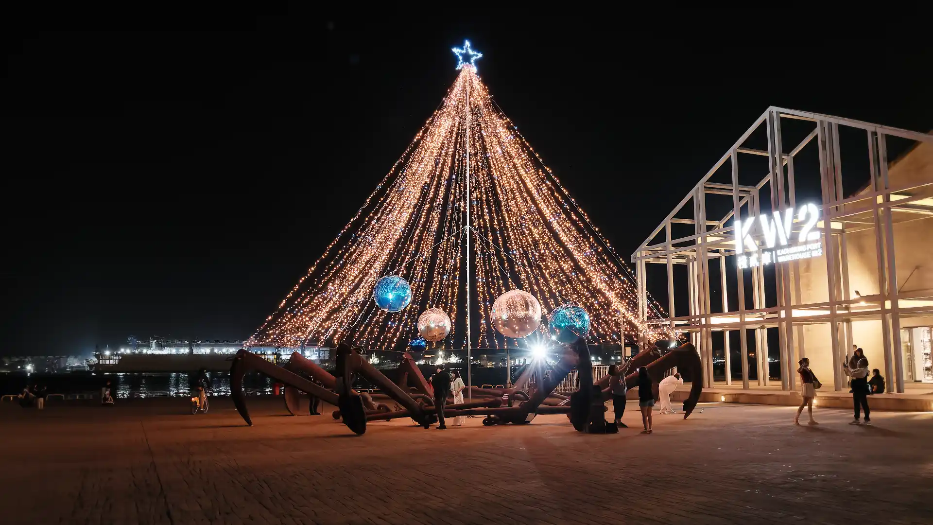 A Christmas tree-like sculpture made of ships’ anchors and string lights, outside a harborside industrial warehouse in Kaohsiung.