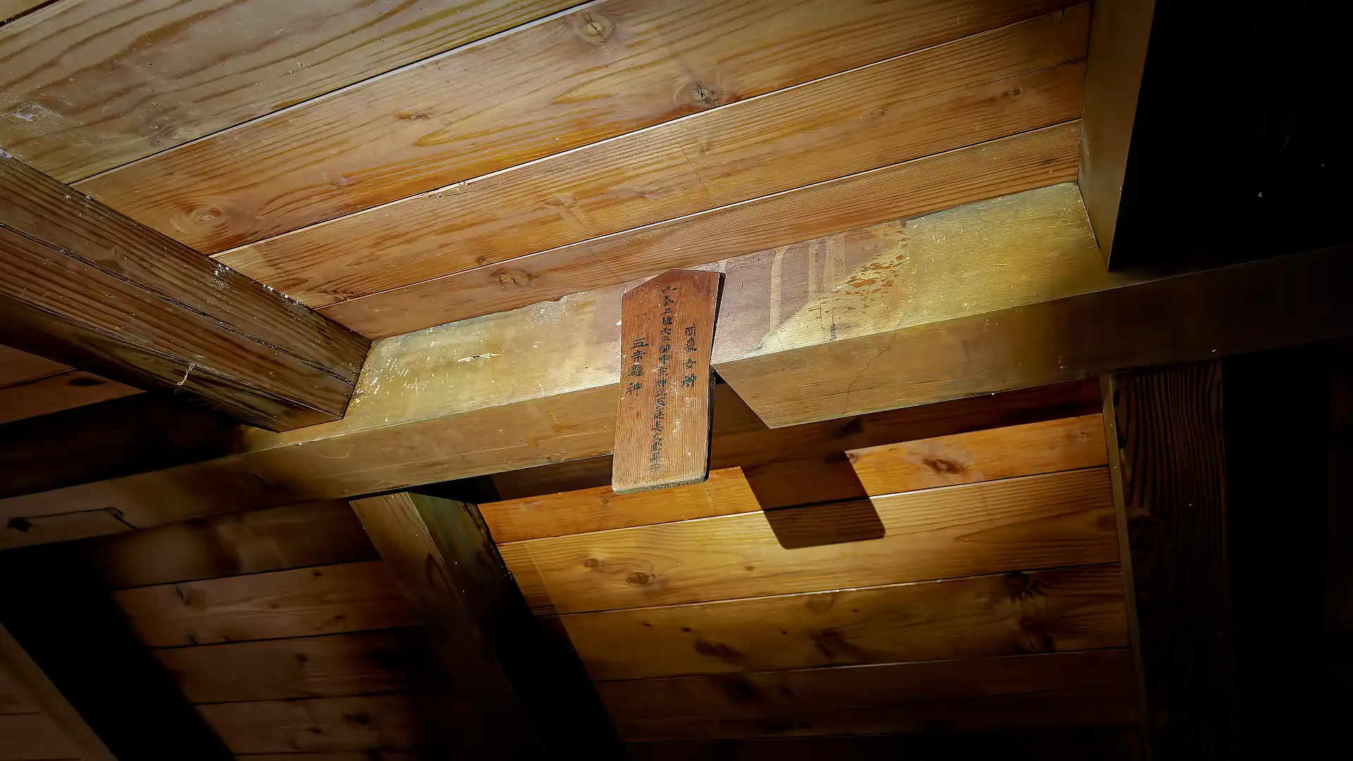 An inscribed wooden plaque affixed to the highest beam in the attic of ‘A Book Wooden House’.