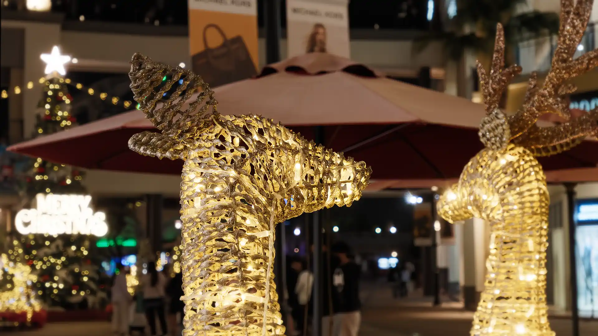 Close-up of the head of a reindeer sculpture, lit with hundreds of tiny lights.