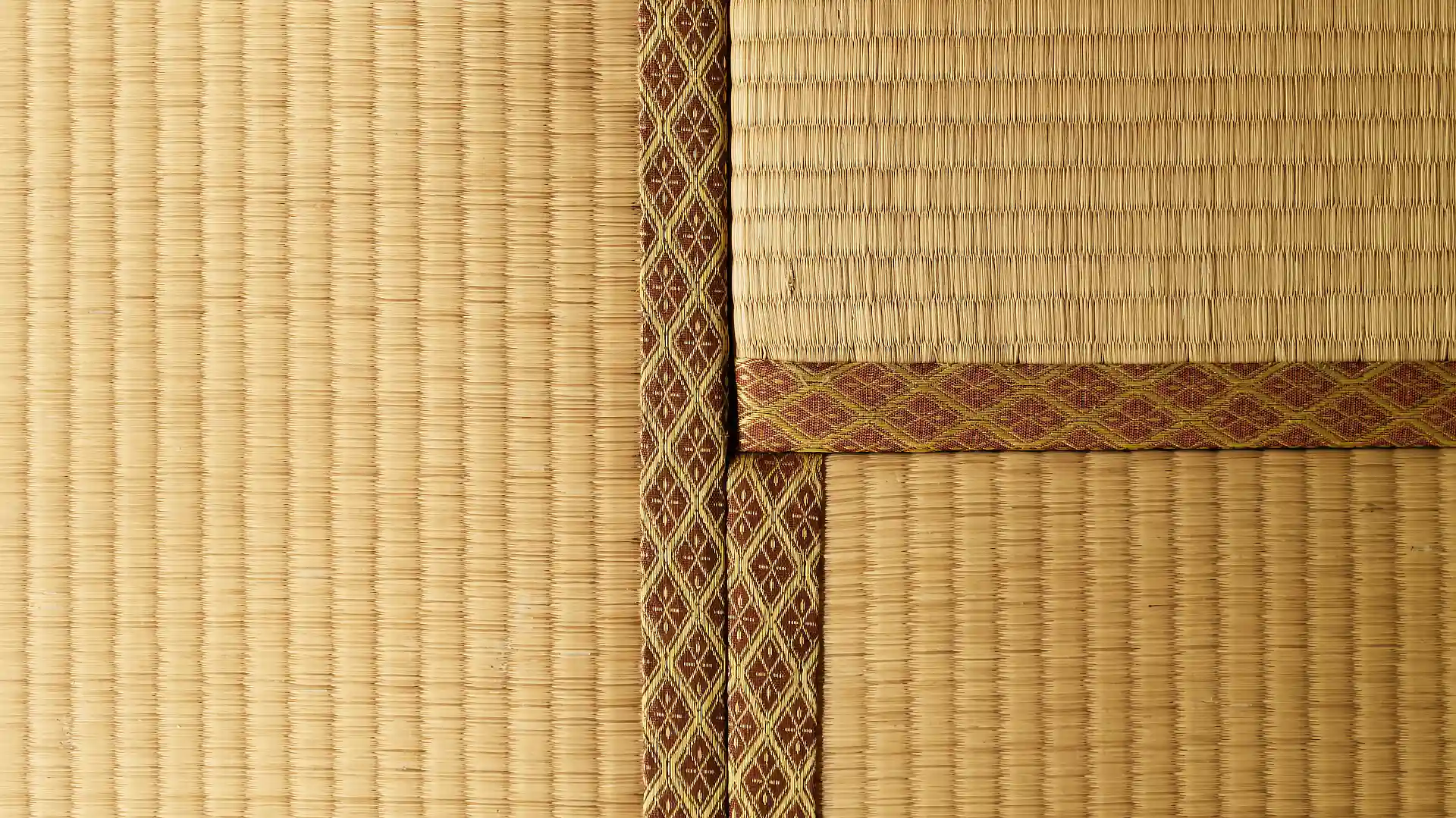 Close-up of the edges of three tatami mats.