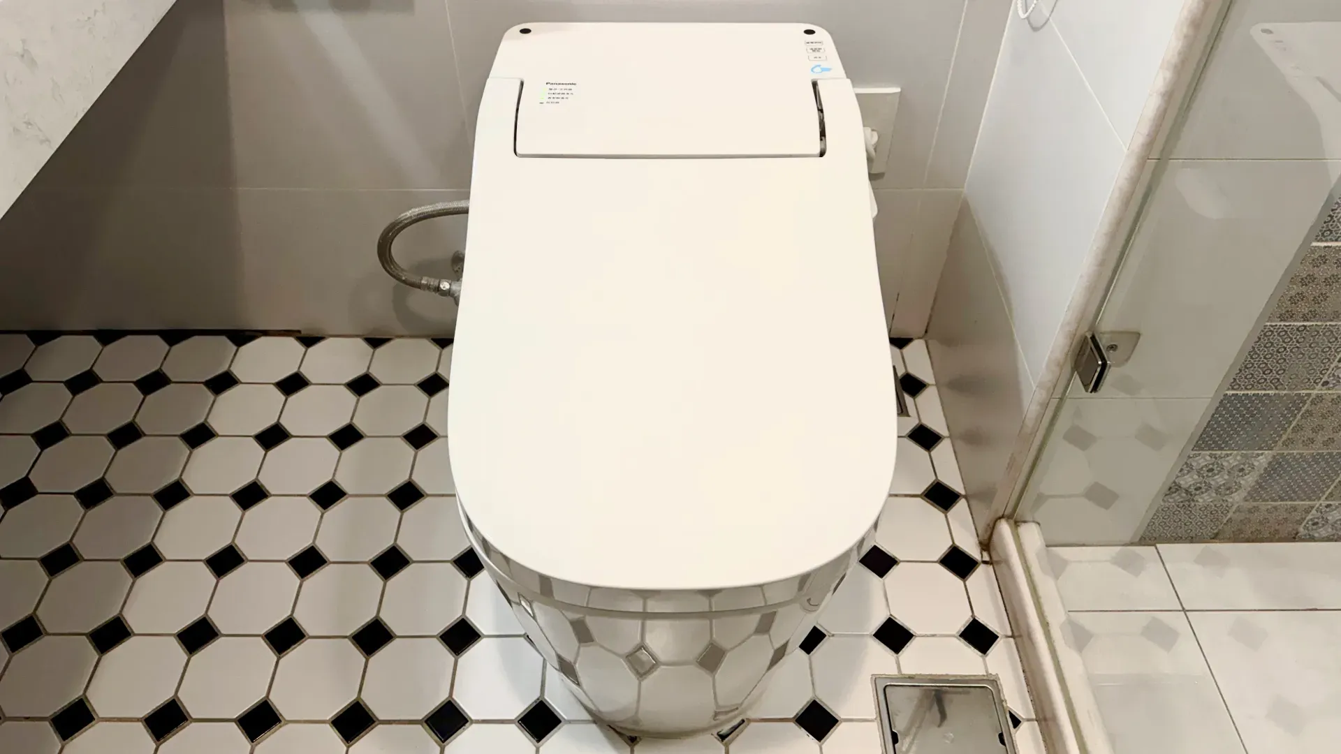 A Panasonic smart toilet with lid closed, in a Taiwanese apartment bathroom.