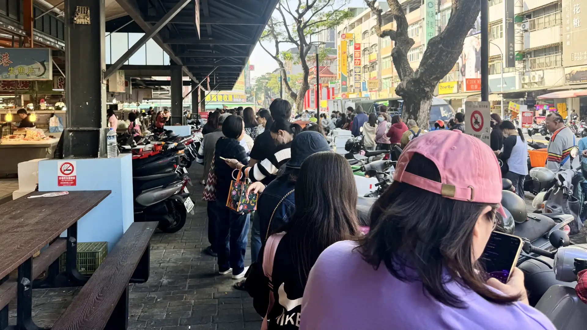 A queue of people outside a covered market in Lingya District, Kaoshiung City, Taiwan.