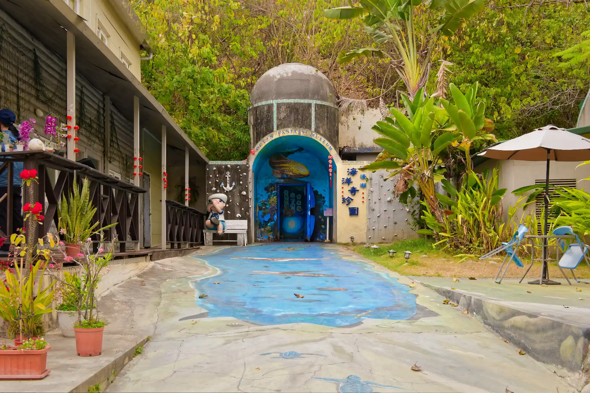 Concrete and steel entrance to a nuclear bunker, set into a hill and now brightly painted with aquatic life murals.