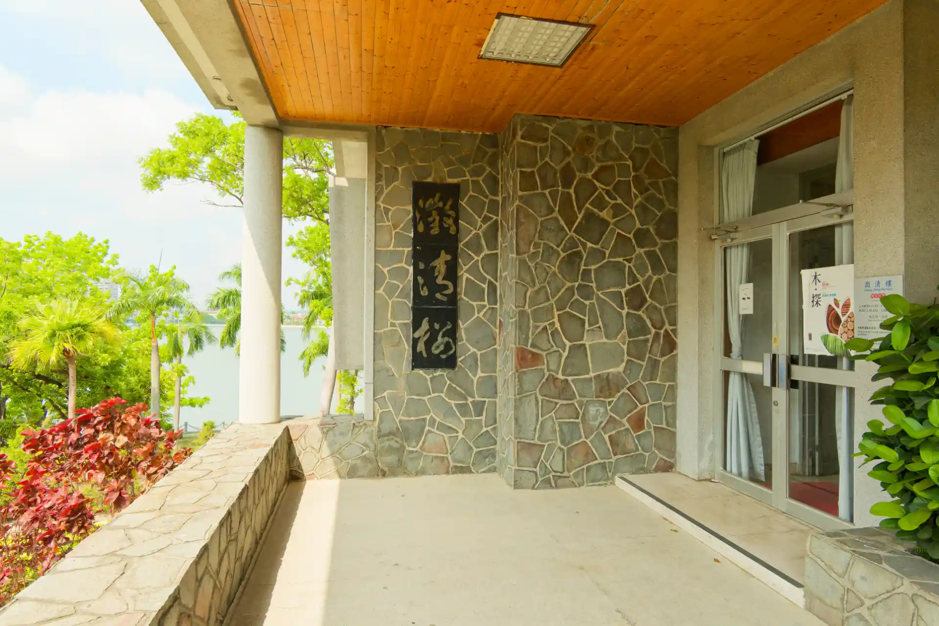 An entrance porch of a large mid-century modern house. There are three Chinese characters displayed on one of the exterior walls.