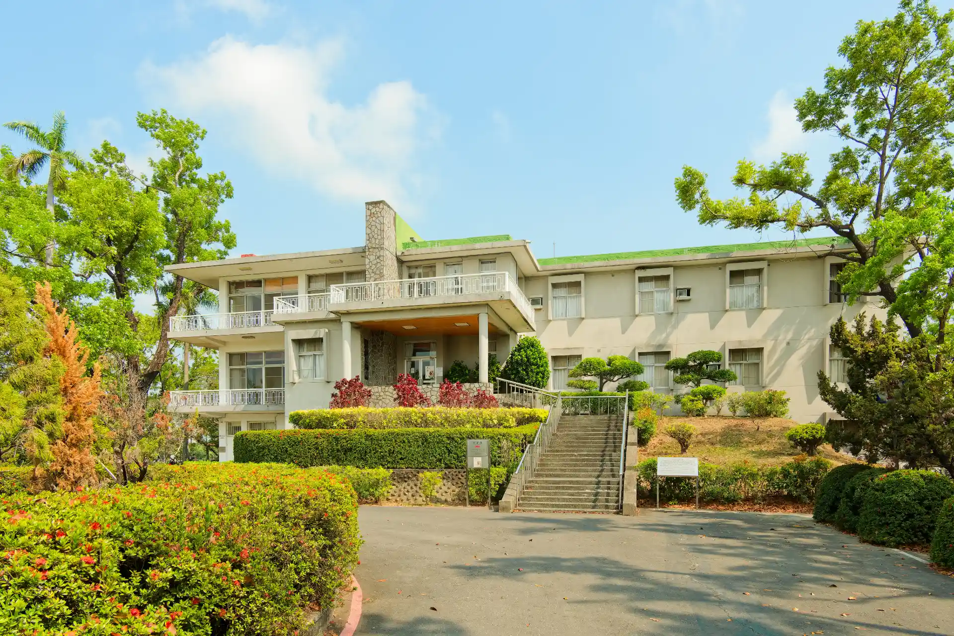 A three-level mid-century modern house surrounded by a carefully-maintained garden.