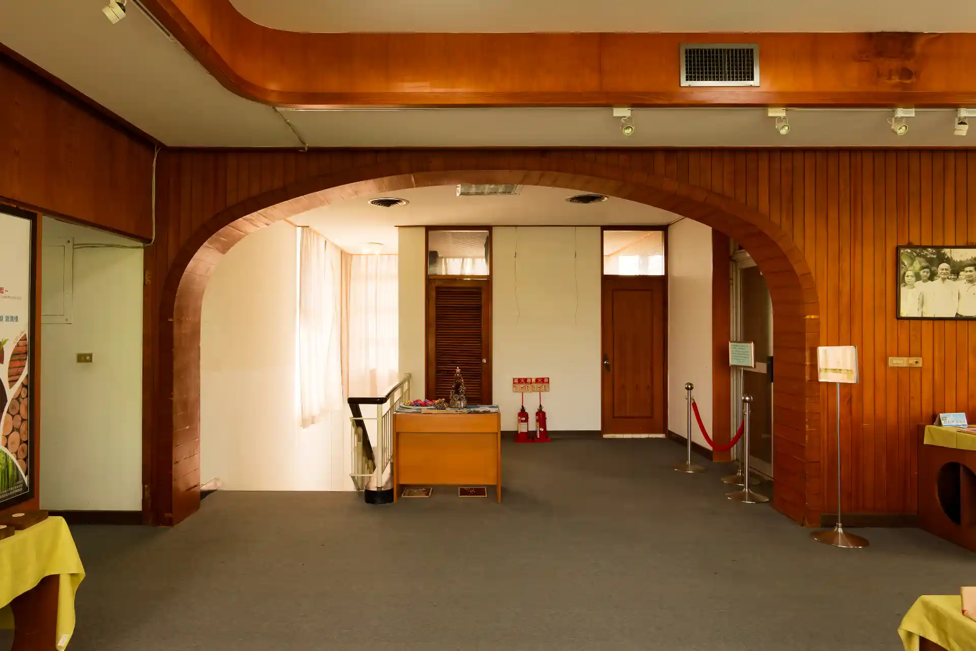 A wide arch in one wall of a room, with stairs leading down to the left, and a few other closed doors leading to other spaces.
