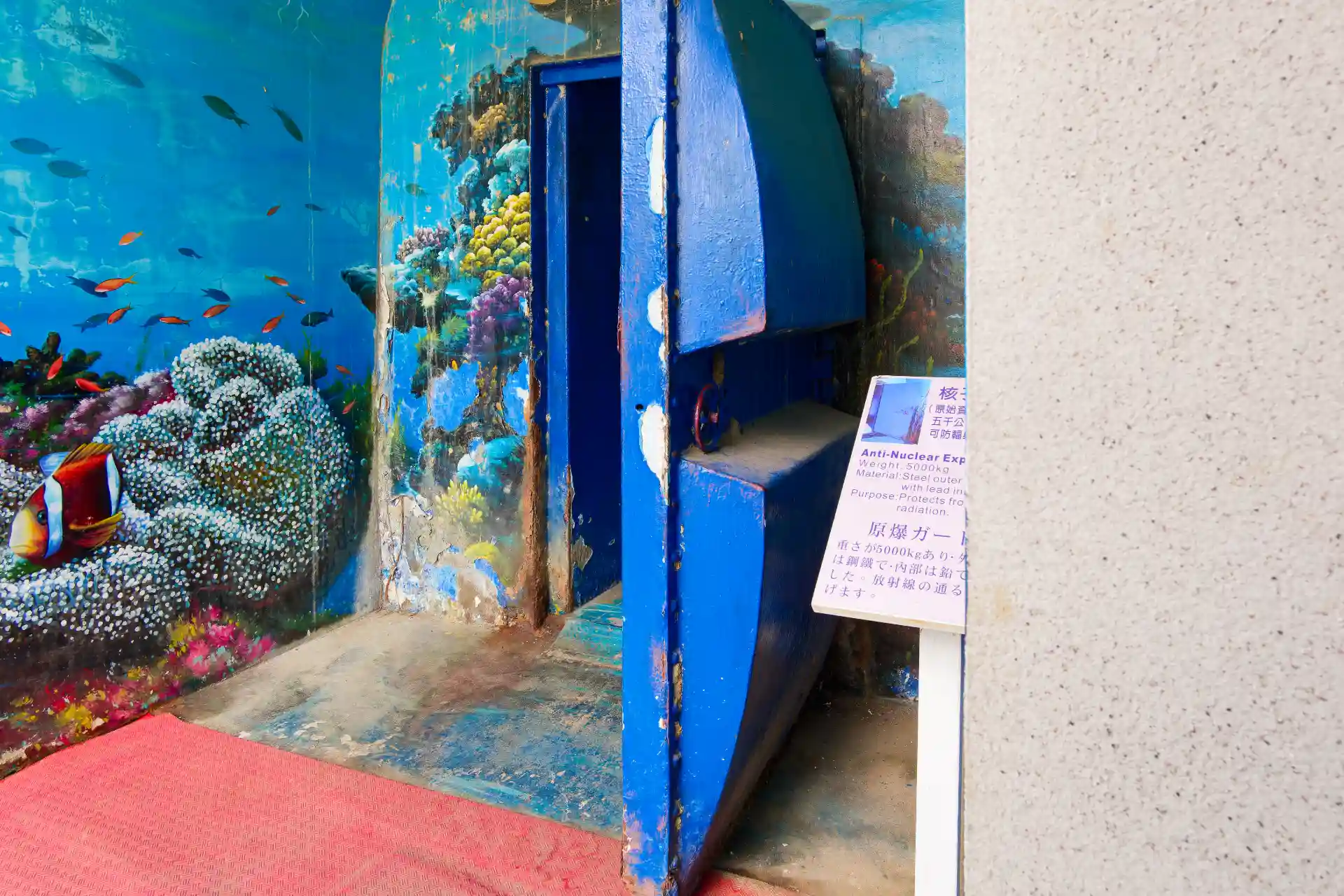 A blue-painted heavy open door of a nuclear bunker.
