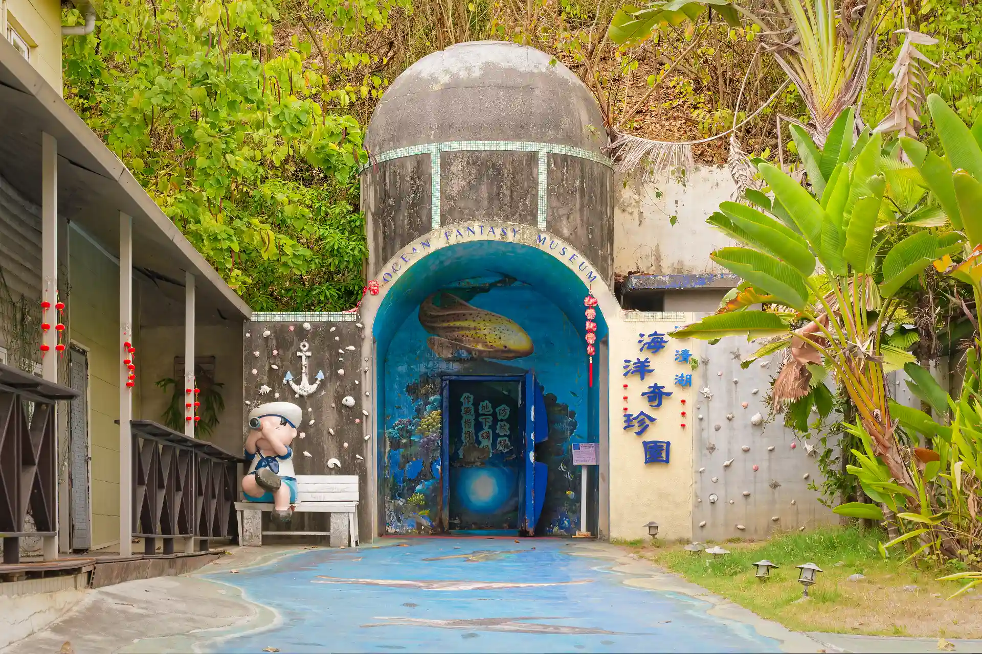 Concrete and steel entrance to a nuclear bunker, set into a hill and now brightly painted with aquatic life murals.