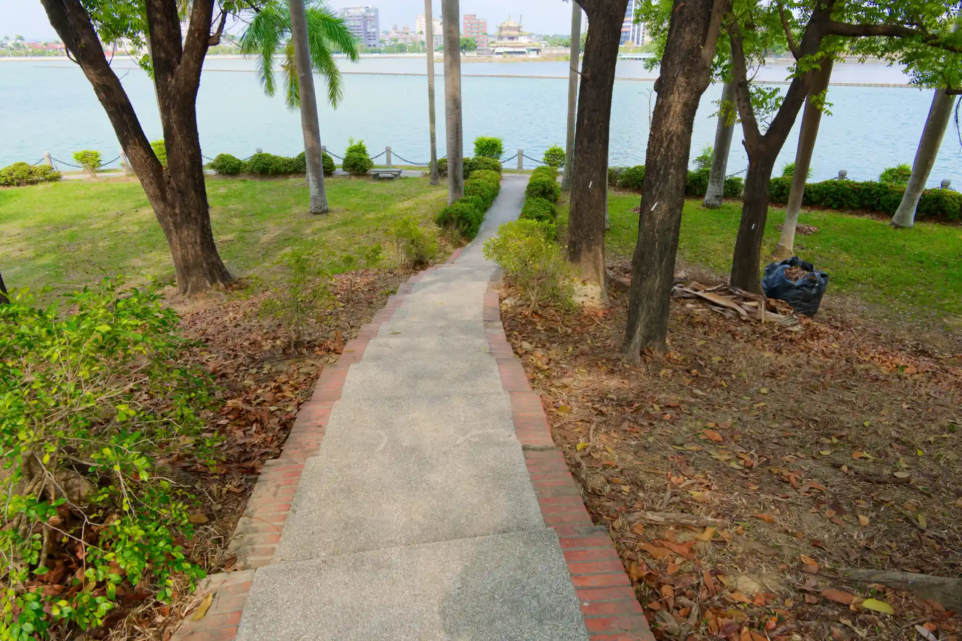 A stepped, curved path leading down a gentle hill to a lake.