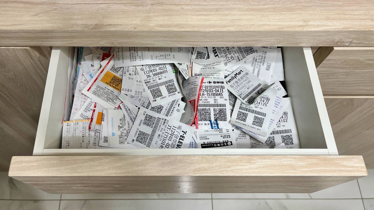 An open drawer full of paper receipts.