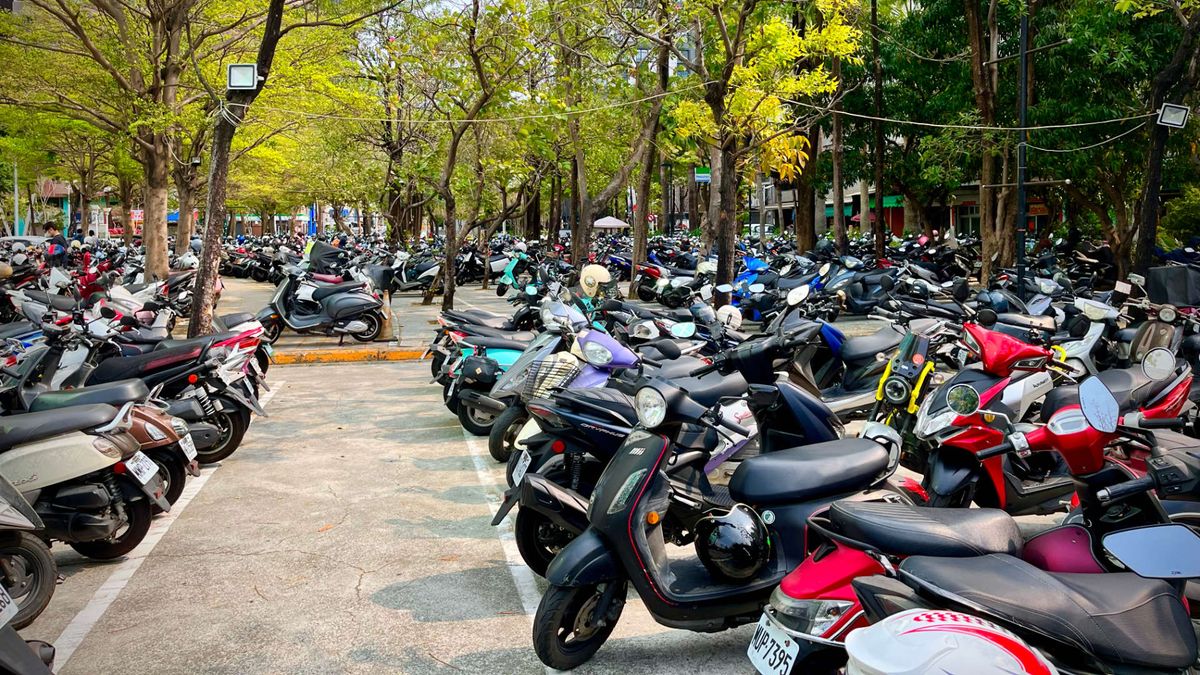 An expansive outdoor scooter parking area, with hundreds of scooters parked into the distance.