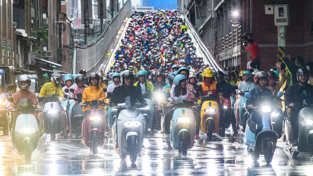 Hundreds of Gogoro scooters being driven, in the rain, down the ‘scooter waterfall’ off-ramp.