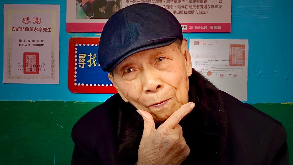 Rainbow Grandpa, Huang Yung-Fu, posing at Rainbow Village, Taiwan.