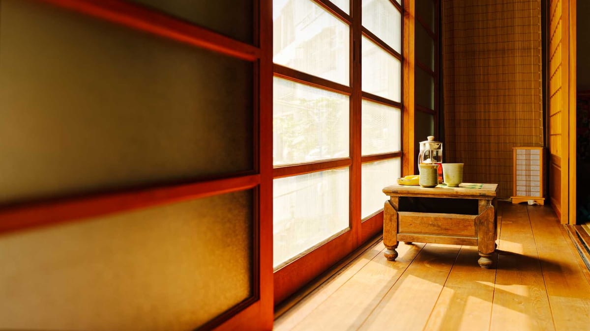 A short wooden table in an indoor–outdoor transition space at ‘A Book Wooden House’, Fangliao, Pingtung, Taiwan.