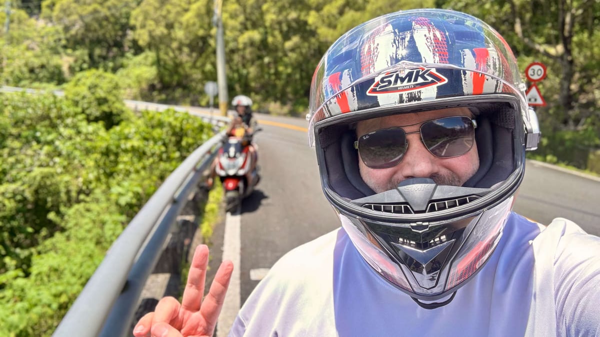 Selfie of a man in a motorcycle helmet on a mountain road in Taiwan.