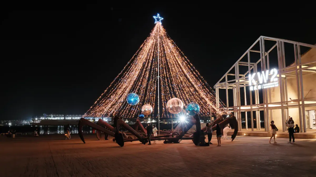 A Christmas tree-like sculpture made of ships’ anchors and string lights, outside a harborside industrial warehouse in Kaohsiung.